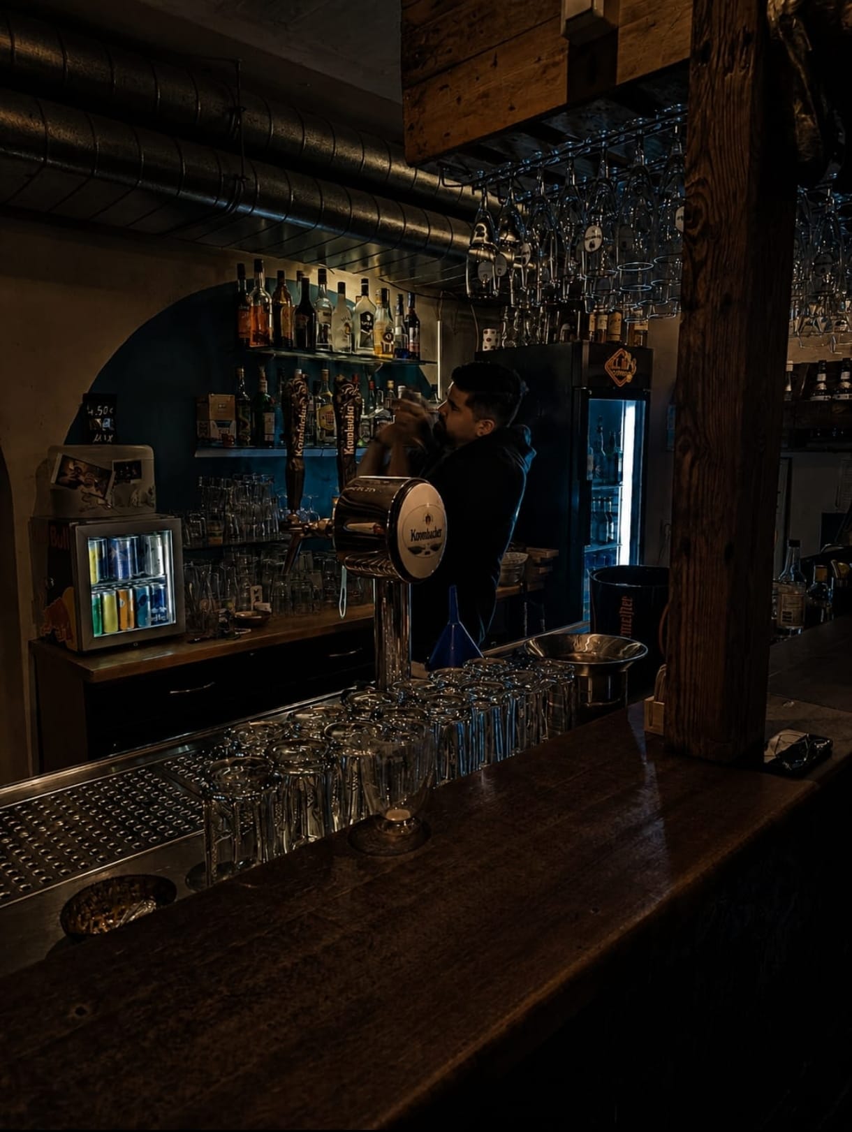 Blick auf die beleuchtete Bar mit Zapfanlage